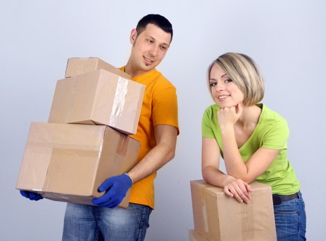 Professional small removals team transporting boxes and furniture